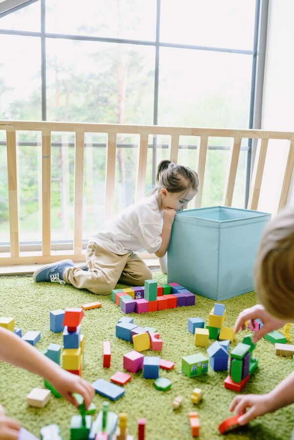 Child building with blocks by a window