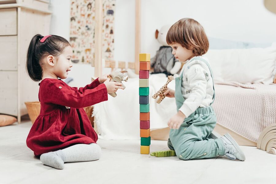 Two children stacking colorful blocks