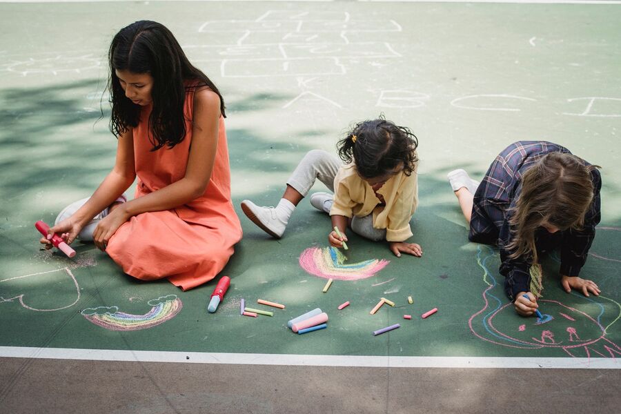 Children practicing letters with chalk