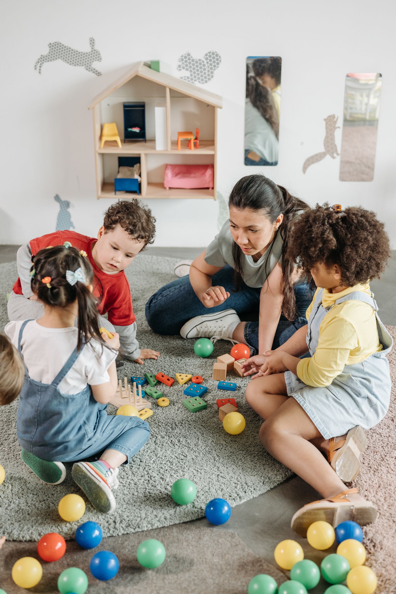 Teacher playing on the floor with a group of preschoolers